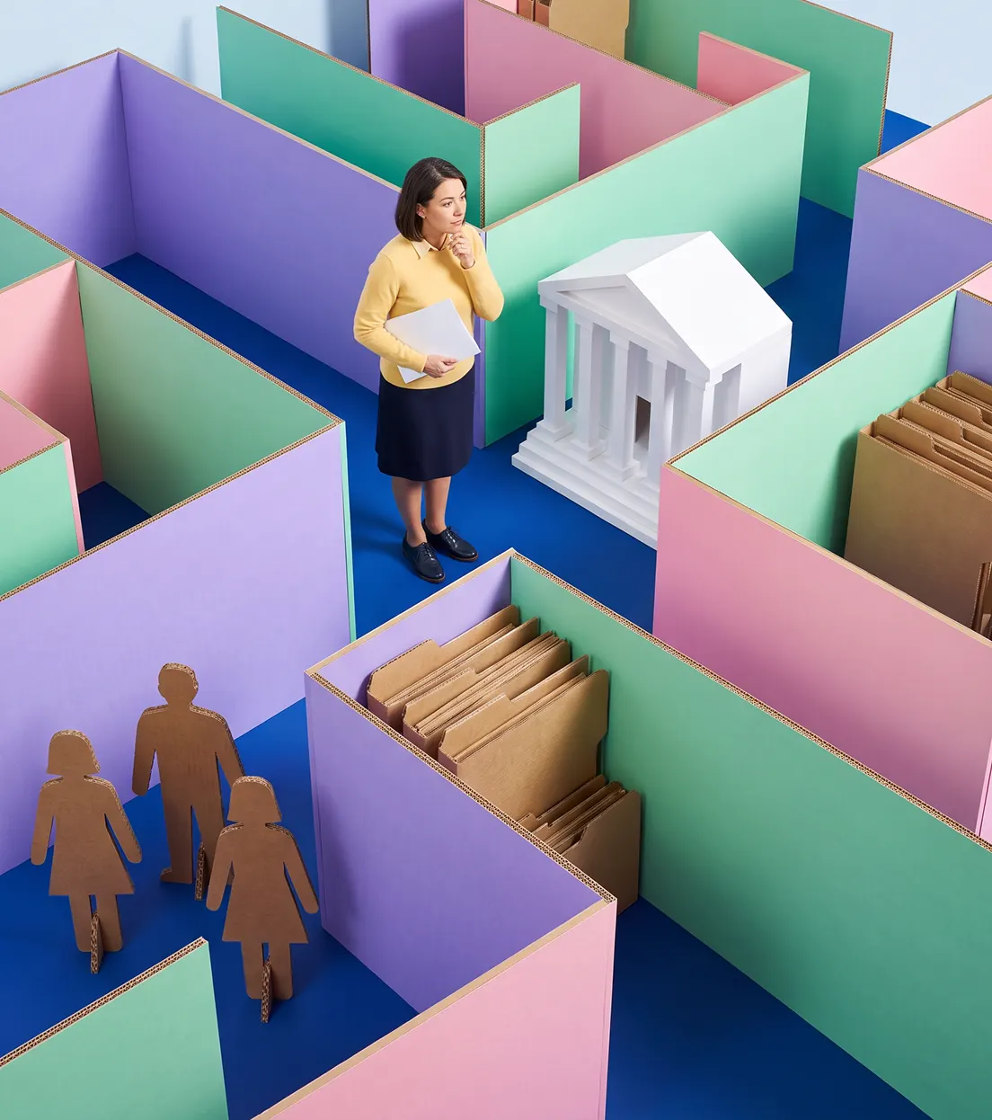 Eine Lehrerin steht in einem Labyrinth aus rosa, grünen und lila Wänden