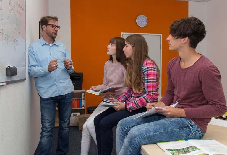 Schülerinnen und Schüler mit Nachhilfelehrer