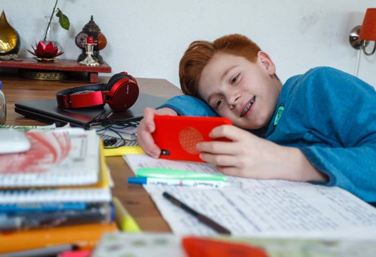 Schüler spielt mit Handy