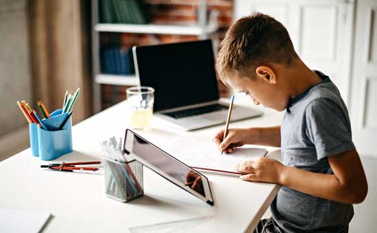 Digitale Medien im Unterricht Beispiele: Schüler lernt mit einem Lernvideo auf seinem Tablet und erledigt dabei Übungsaufgaben.
