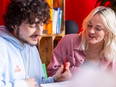 Nachhilfeunterricht zwischen Schüler und Lehrerin am Tisch in einem Studienkreis-Institut.